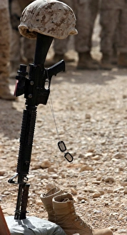 Boots, a helmet, rifle and dog tags serve as a representation of the memory of a soldier Boots, a helmet, rifle and dog tags serve as a representation of the memory of a soldier