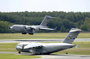 A C-17 Globemaster III performs touch and go landings while another prepares for take-off A C-17 Globemaster III performs touch and go landings while another prepares for take-off
