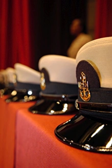 Several chief petty officers combination covers lined up on a table Several chief petty officers combination covers lined up on a table