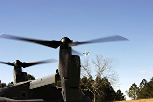 A CV-22 Osprey prepares to take off as an A-10 Thunderbolt II flies overhead A CV-22 Osprey prepares to take off as an A-10 Thunderbolt II flies overhead