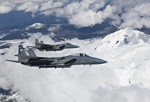 Two F-15 Eagles fly past snow capped peaks in Central Oregon Two F-15 Eagles fly past snow capped peaks in Central Oregon
