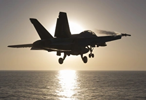 An F/A-18F Super Hornet takes off into the morning Sun over the Arabian Sea An F/A-18F Super Hornet takes off into the morning Sun over the Arabian Sea