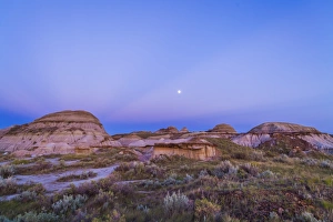 Gibbous moon and crepuscular rays over Dinosaur Provincial Park, Canada Gibbous moon and crepuscular rays over Dinosaur Provincial Park, Canada