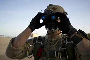 A Green Beret checks attached night vision device A Green Beret checks attached night vision device