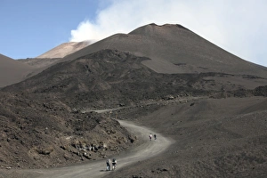 Hikers walking towards summit area of Mount Etna volcano, Sicily, Italy Hikers walking towards summit area of Mount Etna volcano, Sicily, Italy