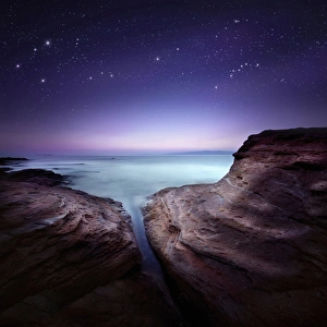 Two large rocks in a sea, against starry sky Two large rocks in a sea, against starry sky