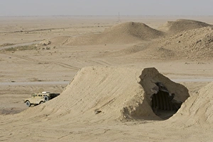 A Mamba armored vehicle sits in front of a Iraqi Magazine that has been hit by a A Mamba armored vehicle sits in front of a Iraqi Magazine that has been hit by a