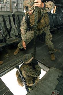 A Marine sends a fellow Marine down the hell hole of a CH-53E Super Stallion A Marine sends a fellow Marine down the hell hole of a CH-53E Super Stallion