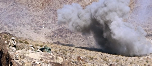 Marines perched atop Machine Gun Hill watch down range as explosives detonate Marines perched atop Machine Gun Hill watch down range as explosives detonate