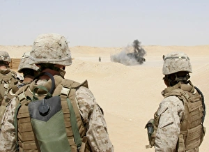 Marines and sailors look on as an explosion goes off Marines and sailors look on as an explosion goes off