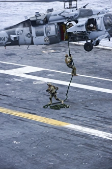 Members conduct a fast roping exercise on the flight deck of USS Carl Vinson Members conduct a fast roping exercise on the flight deck of USS Carl Vinson
