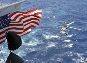 An MH-60S Sea Hawk carries supplies during a replenishment at sea An MH-60S Sea Hawk carries supplies during a replenishment at sea