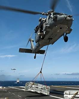 An MH-60S Sea Hawk helicopter lowers cargo onto the deck of USS John C. Stennis An MH-60S Sea Hawk helicopter lowers cargo onto the deck of USS John C. Stennis