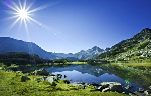Muratov Lake against blue sky and bright sun in Pirin National Park, Bulgaria Muratov Lake against blue sky and bright sun in Pirin National Park, Bulgaria