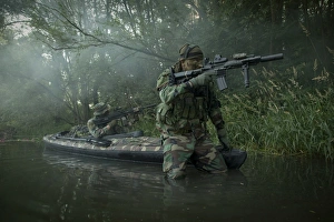 Navy SEALs navigate the waters in a folding kayak during jungle warfare operations Navy SEALs navigate the waters in a folding kayak during jungle warfare operations