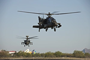 A pair of AH-64D Apache Longbow helicopters taking off A pair of AH-64D Apache Longbow helicopters taking off