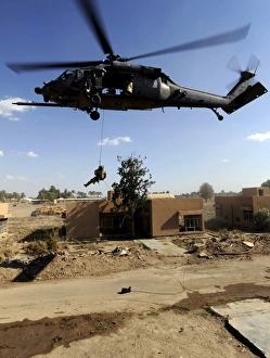 A pararescueman rappels from an HH-60 Pavehawk helicopter A pararescueman rappels from an HH-60 Pavehawk helicopter