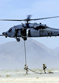 Pararescuemen descend from an HH-60 Pave Hawk helicopter Pararescuemen descend from an HH-60 Pave Hawk helicopter
