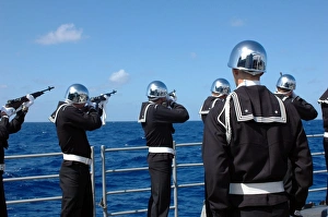 Sailors fire a gun salute during a burial-at-sea Sailors fire a gun salute during a burial-at-sea
