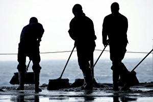 Sailors sweep out the hangar bay aboard the aircraft carrier USS Nimitz Sailors sweep out the hangar bay aboard the aircraft carrier USS Nimitz