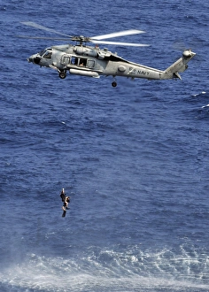 Search and rescue swimmers being hoisted into a helicopter Search and rescue swimmers being hoisted into a helicopter