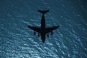 Silhouette of a military aircraft in flight over the Atlantic Ocean Silhouette of a military aircraft in flight over the Atlantic Ocean