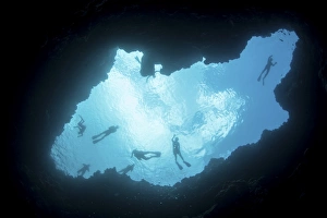Snorkelers swim above a blue hole on Palaus barrier reef Snorkelers swim above a blue hole on Palaus barrier reef