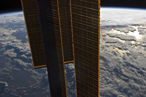 Solar panels of the International Space Station backdropped by a blue and white Earth Solar panels of the International Space Station backdropped by a blue and white Earth