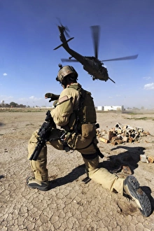 A soldier conducts security for an HH-60 Pavehawk helicopter A soldier conducts security for an HH-60 Pavehawk helicopter