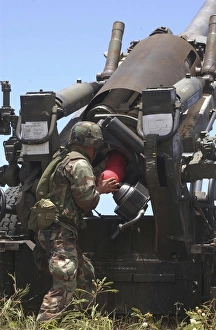 Soldier loads a charge round behind the ammunition round of the Howitzer 150 gun Soldier loads a charge round behind the ammunition round of the Howitzer 150 gun