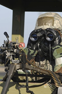 A soldier looks through binoculars from his outpost A soldier looks through binoculars from his outpost