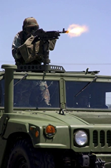 Soldier shoots a M-240B machine gun atop a humvee Soldier shoots a M-240B machine gun atop a humvee