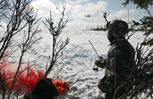 A soldier uses red smoke to signal the nearby HH-60 Pave Hawk helicopter A soldier uses red smoke to signal the nearby HH-60 Pave Hawk helicopter