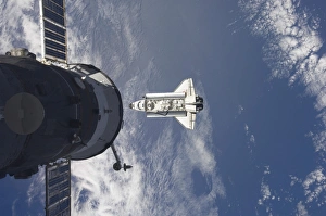 Space Shuttle Atlantis and a Russian spacecraft backdropped by a blue and white Earth Space Shuttle Atlantis and a Russian spacecraft backdropped by a blue and white Earth