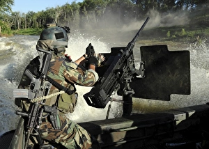 A Special Warfare Combatant-craft Crewman reloading an M2 Heavy Barrel A Special Warfare Combatant-craft Crewman reloading an M2 Heavy Barrel