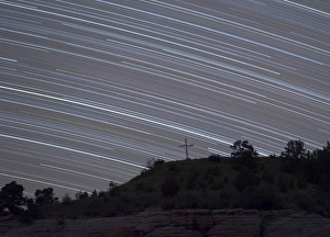 Star trails arch over a cross on a hill in Oklahoma Star trails arch over a cross on a hill in Oklahoma