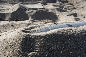 A static display of an ordnance shell and a mine lay half-buried in the sand A static display of an ordnance shell and a mine lay half-buried in the sand