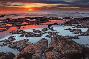Tidal pools reflect the sunrise colors during the autumn equinox Tidal pools reflect the sunrise colors during the autumn equinox