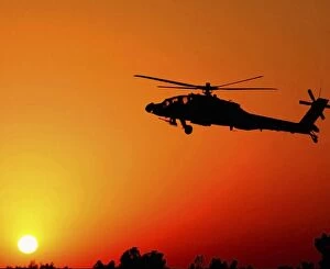 Ah 64 Collection: A U. S. Army AH-64 Apache Helicopter prepares to land as the sun comes up