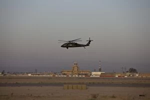 Air Traffic Control Tower Collection: A UH-60 Blackhawk helicopter flies past the tower on Camp Speicher
