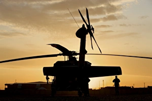 A UH-60L Black Hawk helicopter silhouetted by the setting sun A UH-60L Black Hawk helicopter silhouetted by the setting sun