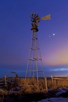 Venus and Jupiter are visible behind an old farm water pump windmill, Alberta, Canada Venus and Jupiter are visible behind an old farm water pump windmill, Alberta, Canada