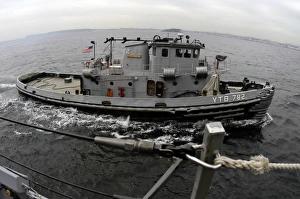 A Yokosuka Naval tugboat prepares to assist the guided missile destroyer USS Curtis A Yokosuka Naval tugboat prepares to assist the guided missile destroyer USS Curtis