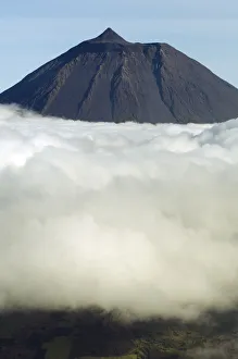 Clouds around Pico, the highest mountain in Portugal, sticking out through a loayer of clouds Clouds around Pico, the highest mountain in Portugal, sticking out through a loayer of clouds