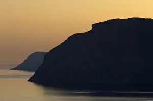 Coastal cliffs silhouetted at dawn near Mochlos, Crete, Greece, April 2009 Coastal cliffs silhouetted at dawn near Mochlos, Crete, Greece, April 2009