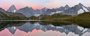 Colourful pink sky at dawn reflected in Fenetre Lake / Lac de Fenetre in Swiss Alps Colourful pink sky at dawn reflected in Fenetre Lake / Lac de Fenetre in Swiss Alps