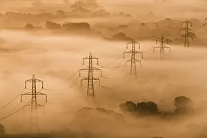 Electricity pylons rising through mist at dawn, view of The Marshwood Vale from Lambert's Electricity pylons rising through mist at dawn, view of The Marshwood Vale from Lambert's
