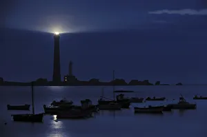 Fishing boats and lighthouse at night on the island Ile Vierge, Brittany, France Fishing boats and lighthouse at night on the island Ile Vierge, Brittany, France