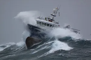 Fishing vessel Harvester powering through huge waves while operating in the North Sea Fishing vessel Harvester powering through huge waves while operating in the North Sea