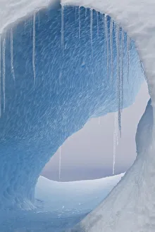 A large hole in an iceberg with icicles hanging. Yalour Islands, Antarctic Peninsula A large hole in an iceberg with icicles hanging. Yalour Islands, Antarctic Peninsula